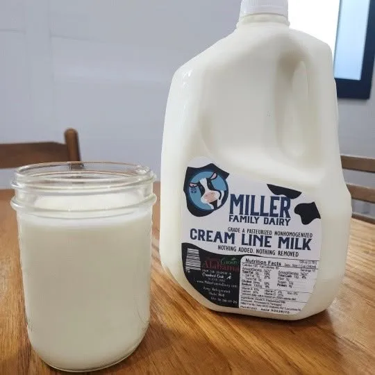 Gallon of Miller Family Dairy cream line milk next to a glass of milk