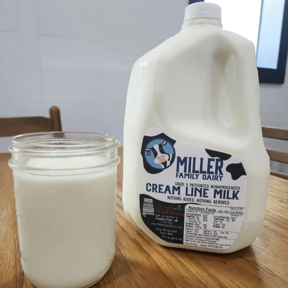 A gallon of Miller Family Dairy cream line milk next to a glass of milk